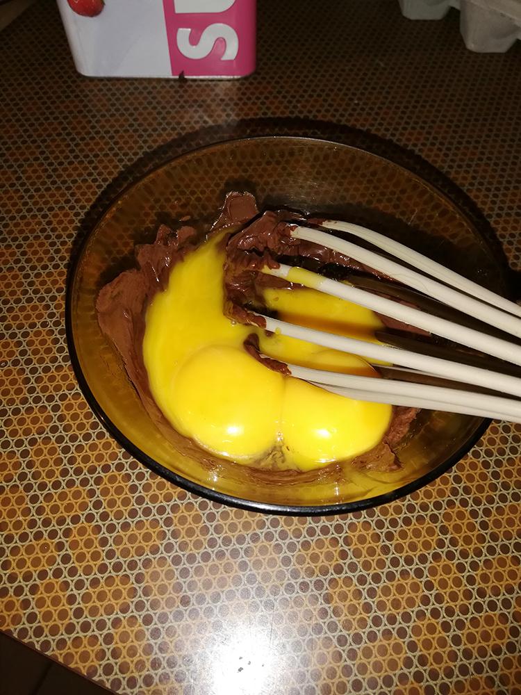 On mélange les jaunes d'œufs et les sucres au chocolat fondu.